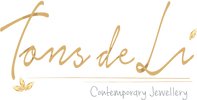 Logo of Tons de Li with gold cursive text and butterfly illustrations on a white background